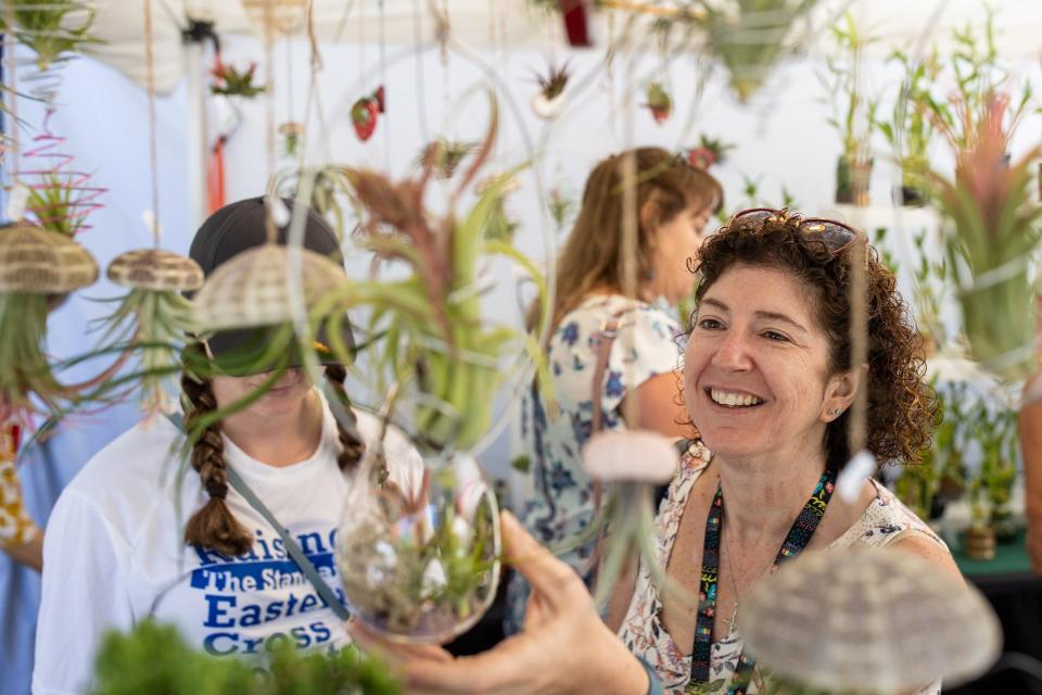 Lynette Rataiczak, right, browses air plants at Ping Yang's vendor booth during the 2021 St. James Court Art Show. Oct. 1, 2021