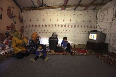 A Syrian refugee from Raqqa (who asked to withhold his name), rests with his family inside his tent after a day's work harvesting cannabis in the Bekaa valley, Lebanon October 19, 2015. REUTERS/Alia Haju