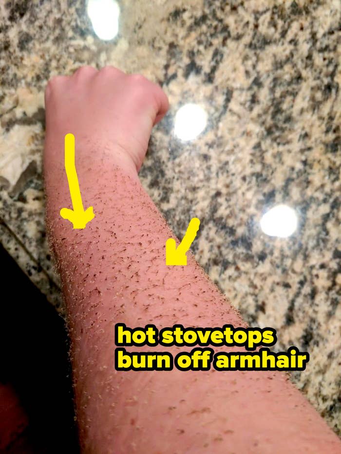 A forearm covered in sugar and coffee grounds, likely after an exfoliation treatment, is held over a granite countertop