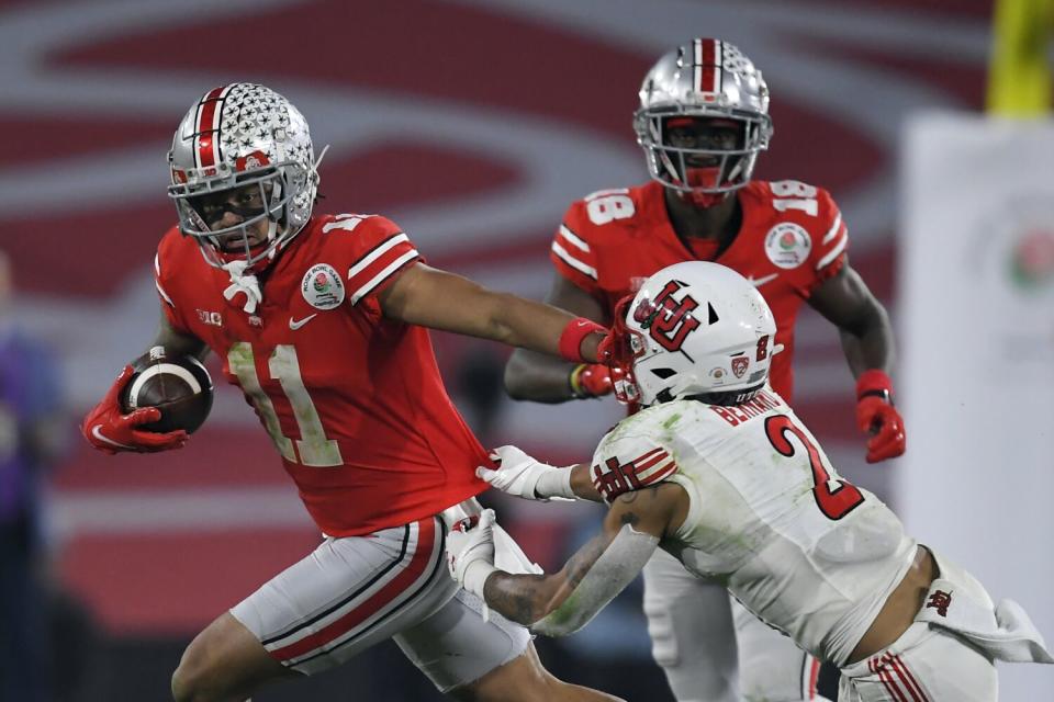 Ohio State wide receiver Jaxon Smith-Njigba stiff arms Utah cornerback Kenzel Lawler.