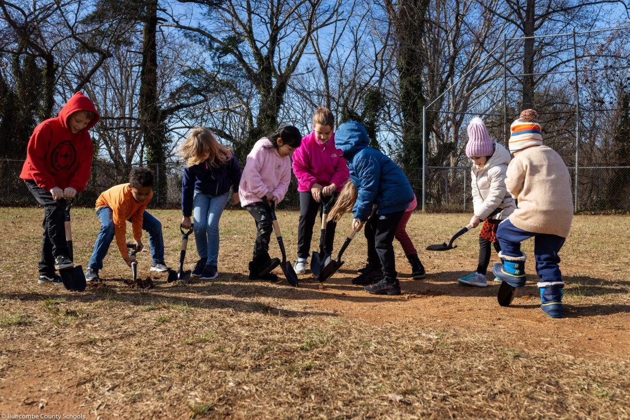 A number of students ceremonially "break ground" on the construction of Woodfin Elementary's new playground equipment, which was funded through community donors and approved by the Buncombe County Board of Education on Dec. 6.