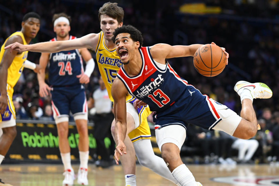 Washington Wizards guard Jordan Poole, right drives against Los Angeles Lakers guard Austin Reaves during the first half of an NBA basketball game Wednesday, April 3, 2024, in Washington. (AP Photo/John McDonnell)