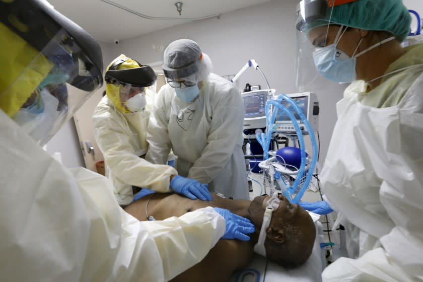 HOUSTON, TEXAS-JULY 1, 2020-Medical Student Osvaldo Perez, 40, (center) and Leyanet Gonzalez, 27 (right) attempt to rescucitate COVID-19 patient Terry Hill, 65, as Dr. Jospeh Varon, left, checks for a pulse on Wednesday at Houston's United Memorial Medical Center. At United Memorial Medical Center in Houston, Texas, Dr. Joseph Varon leads a team to fight the increasing number of coronavirus patients in the expanded Covid-19 ward on July 1, 2020. (Carolyn Cole/Los Angeles Times)