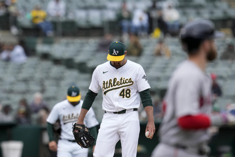 Oakland Athletics pitcher T.J. McFarland (48) stands on the mound after intentionally walking Boston Red Sox's Trevor Story, foreground, to load the bases with one out during the eighth inning of a baseball game Wednesday, April 3, 2024, in Oakland, Calif. (AP Photo/Godofredo A. Vásquez)