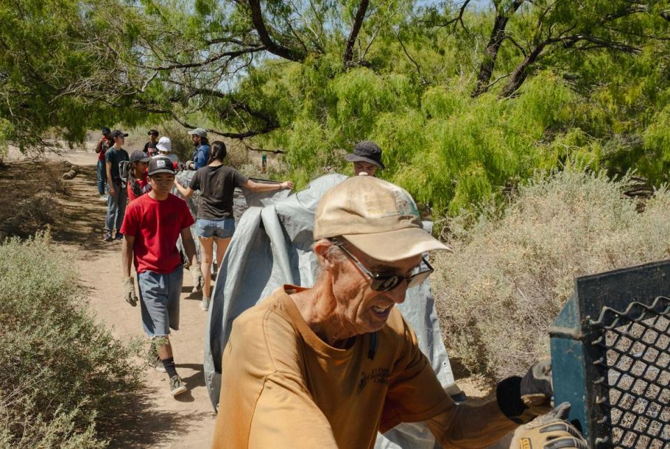 John Sproul, manager of the Rio Bosque Park (right), works with a group of students from Jefferson High School carrying cut branches of invasive salt cedar to be disposed of in the Rio Bosque Wetlands Park. TxDOT is planning an expansion of the Loop 375 Border Highway through the park in Socorro, Texas. May 4, 2024.