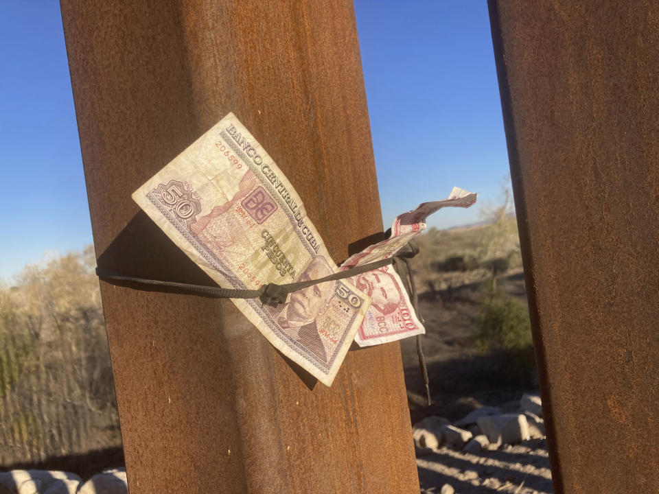 Cuban currency, left behind by a migrant, is tied to the border wall in Yuma, Ariz., Saturday, Feb. 5, 2022. For nationalities that don't need a visa, Mexico is often the ticket to seeking asylum in the United States. (AP Photo/Elliot Spagat)