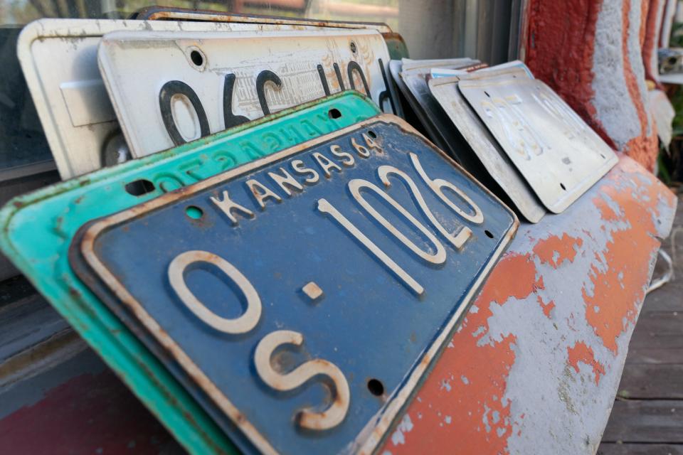 A collection of old Kansas license plates with embossed lettering are seen on a windowsill at the Truckhenge property in East Topeka. If your vehicle still uses an embossed plate, the state may be sending you a new one that uses flat tag numbers printed digitally.