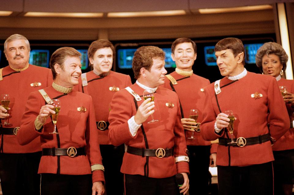 Members of the "Star Trek" crew, from left, James Doohan, DeForest Kelley, Walter Koenig, William Shatner, George Takei, Leonard Nimoy and Nichelle Nichols, toast the newest "Star Trek" film during a news conference at Paramount Studios in Los Angeles, Dec. 28, 1988.