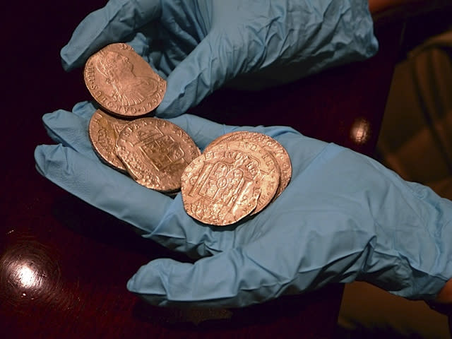 Gold coins from a treasure trove of gold and silver coins worth $500 million and recovered from a Spanish ship believed to be from the wreckage of the Nuestra Senora de las Mercedes, a ship sunk by the British Navy in 1804 as it returned from South America, are handled by a Spanish expert at an undisclosed warehouse in Sarasota, Florida in this handout photo released February 23, 2012. The treasure of 594,000 gold and silver coins was the focus of an intense five-year legal battle between Spain and Odyssey, a U.S. deep sea salvage company that found them five years ago off the coast of Portugal. Two Spanish C-130 military planes have landed at a U.S. Air Force base in Tampa to transport the coins under armed guard, said Guillermo Corral, the cultural attache at Spain's Embassy in Washington. REUTERS/Spanish Embassy/Handout