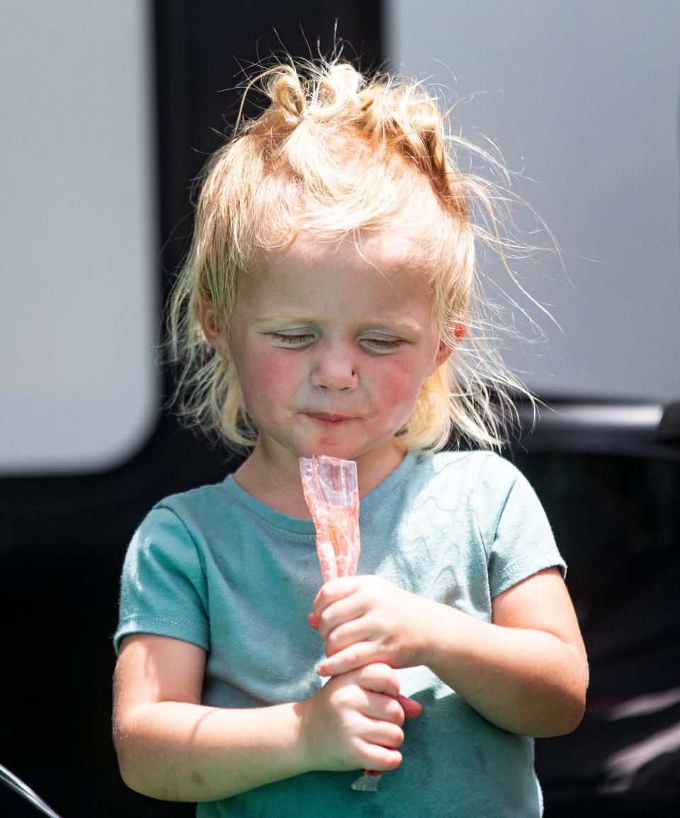 Sayler, 22 months, cools off with a freeze pop while playing with her family on San Carlos Island on Fort Myers Beach on July 24. The family was enduring a hot morning outside their RV.