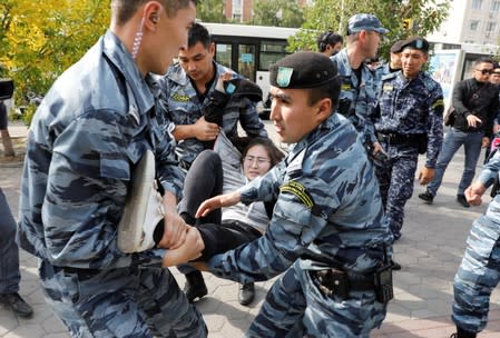 Kazakh law enforcement officers detain a woman during a rally held by opposition supporters in Nur-Sultan