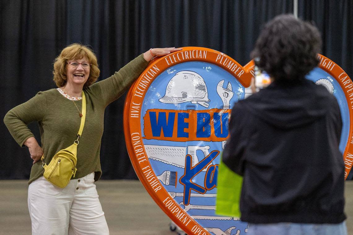 Artist Beth Martens poses for a photo next to her heart display titled “We Build Kansas City” Friday during the Parade of Hearts reveal kickoff event.