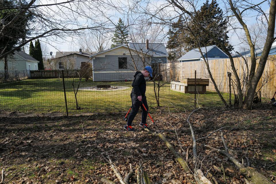 Sam Bliss, 11, cleans a backyard of dog waste in Charlotte Saturday, March 2, 2024. Sam has a method of cleaning the area in rows so he doesn't miss anything.