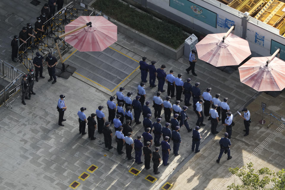 Chinese police and security personnel prepare for duty outside the Evergrande headquarters in Shenzhen, China, Friday, Sept. 24, 2021. Things appeared quiet at the headquarters of the heavily indebted Chinese real estate developer Evergrande, one day after the day it had promised to pay interest due to bondholders in China. (AP Photo/Ng Han Guan)