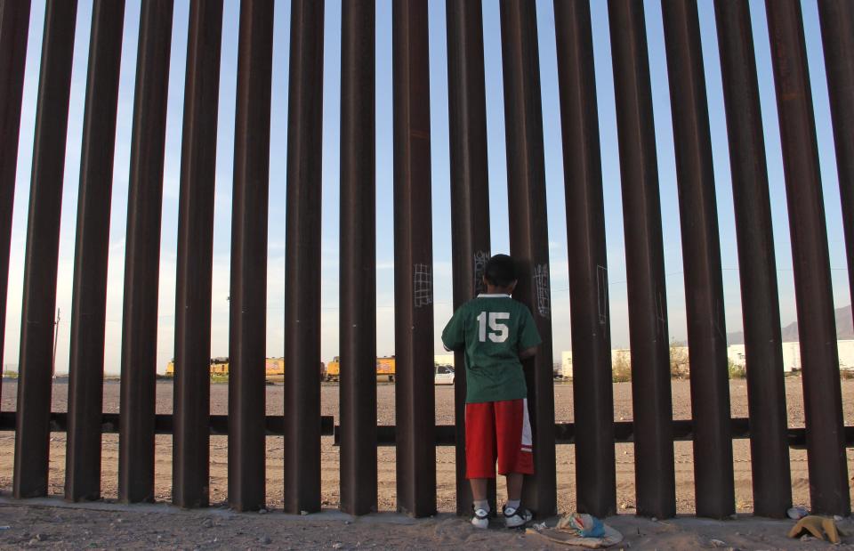 A Mexican child looks at a vehicle of the US border patrol through the US-Mexico fence in Ciudad Juarez, Chihuahua state, Mexico on 4 April, 2018. Human rights organisations have urged the US government to stop deporting Mexican children in rapid removals.  (AFP via Getty Images)