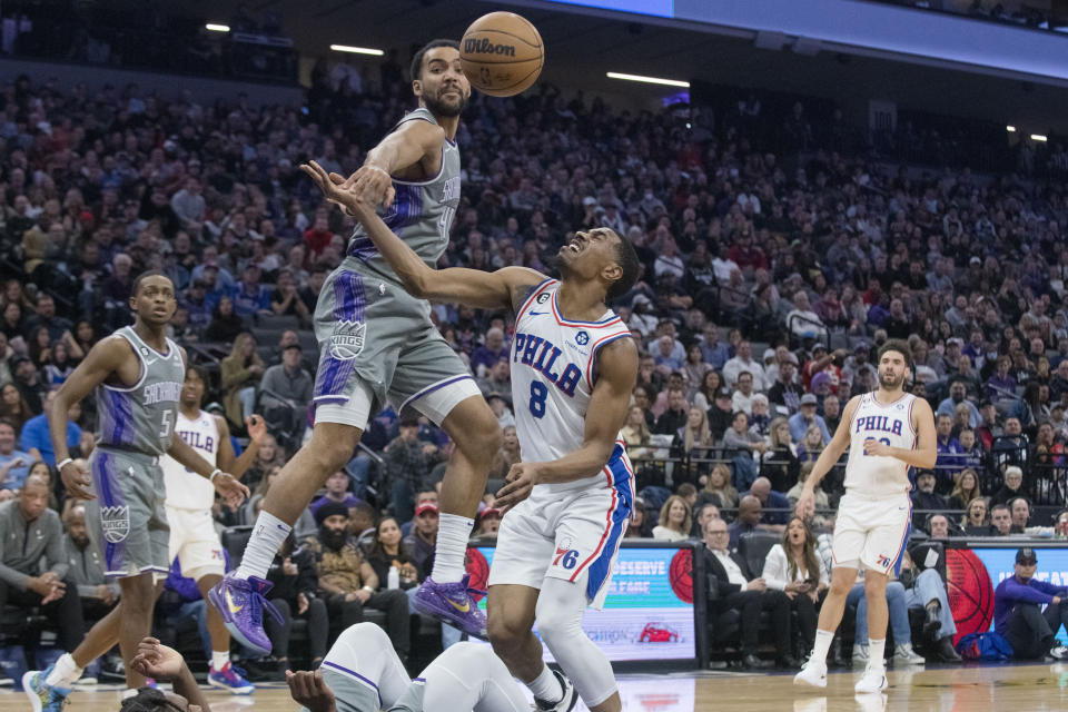 Sacramento Kings forward Trey Lyles, left, and Philadelphia 76ers guard De'Anthony Melton (8) vie for the ball during the first quarter of an NBA basketball game in Sacramento, Calif., Saturday, Jan. 21, 2023. (AP Photo/Randall Benton)