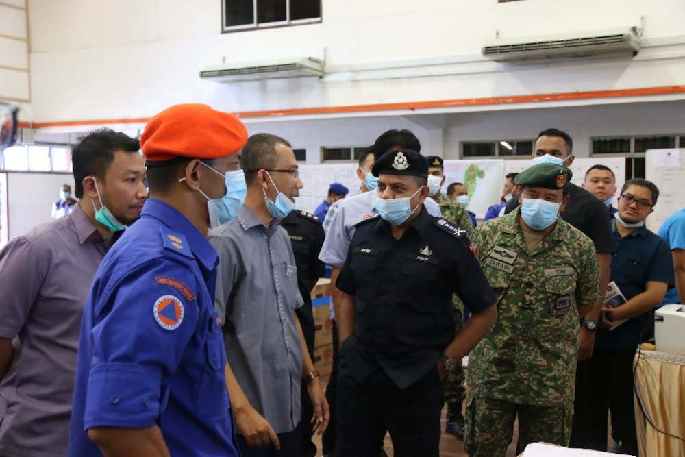 Johor police chief Datuk Ayob Khan Mydin Pitchay (centre) being briefed on the situation during his visit to the two areas in Simpang Renggam that are under the enhanced movement control order April 1, 2020. — Picture courtesy of Johor Police