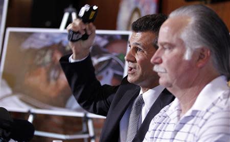 Garo Mardirossian, attorney for Ron Thomas (R), father of Kelly Thomas, gestures with a taser gun as he describes the actions of police officers during their beating of Kelly Thomas, during a news conference in Los Angeles, California January 14, 2014. REUTERS/Alex Gallardo