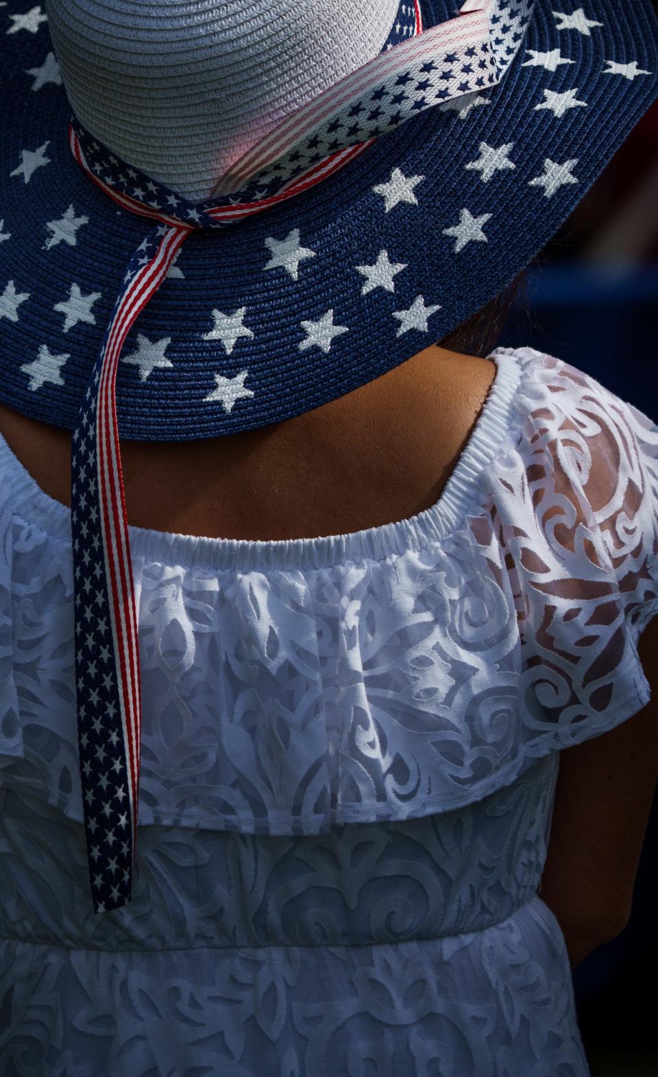 A woman in attendance Friday, July 1, 2022, during a naturalization ceremony at the Benjamin Harrison Presidential Site, wheres an American flag themed hat. 