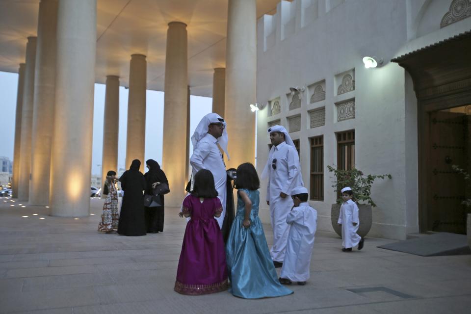 FILE - Qatari families meet during a cultural event at the Msheireb district in Doha, Qatar, May 6, 2018. The foreign fans descending on Doha for the 2022 FIFA World Cup will find a country where women work, hold public office and cruise in their supercars along the city's palm-lined corniche. (AP Photo/Kamran Jebreili, File)