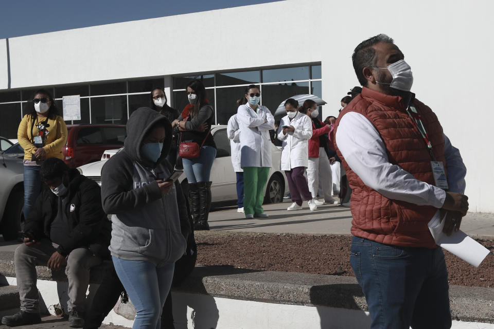 Health care workers wait in line outside General Hospital to receive the Pfizer COVID-19, on the first day of coronavirus vaccinations in Ciudad Juarez, Mexico, Wednesday, Jan. 13, 2021. (AP Photo/Christian Chavez)