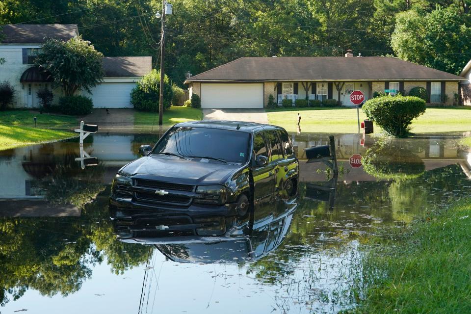 An SUV rests in flood waters in this northeast Jackson, Miss., neighborhood, Monday, Aug. 29, 2022. Flooding affected a number neighborhoods that are near the Pearl River. (AP Photo/Rogelio V. Solis)