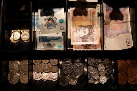 Pound Sterling notes and change are seen inside a cash resgister in a coffee shop in Manchester