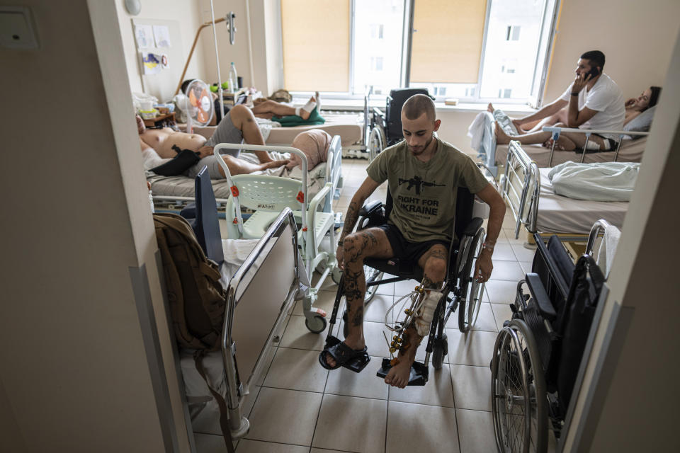 Stas Tkachenko, nicknamed Kipish, a Ukrainian soldier from the 3rd assault brigade, uses a wheelchair at St. Panteleimon hospital in Lviv, Ukraine, Tuesday, July 25, 2023. He was wounded June 28 near Bakhmut. The bullet pierced two bones in the leg and placed his own tourniquet before he bled out. Ukraine is facing the prospect of a future with upwards of 20,000 amputees, many of them soldiers who are also suffering psychological trauma from their time at the front. (AP Photo/Evgeniy Maloletka)