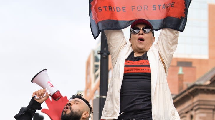 Two people cheer loud at a race.