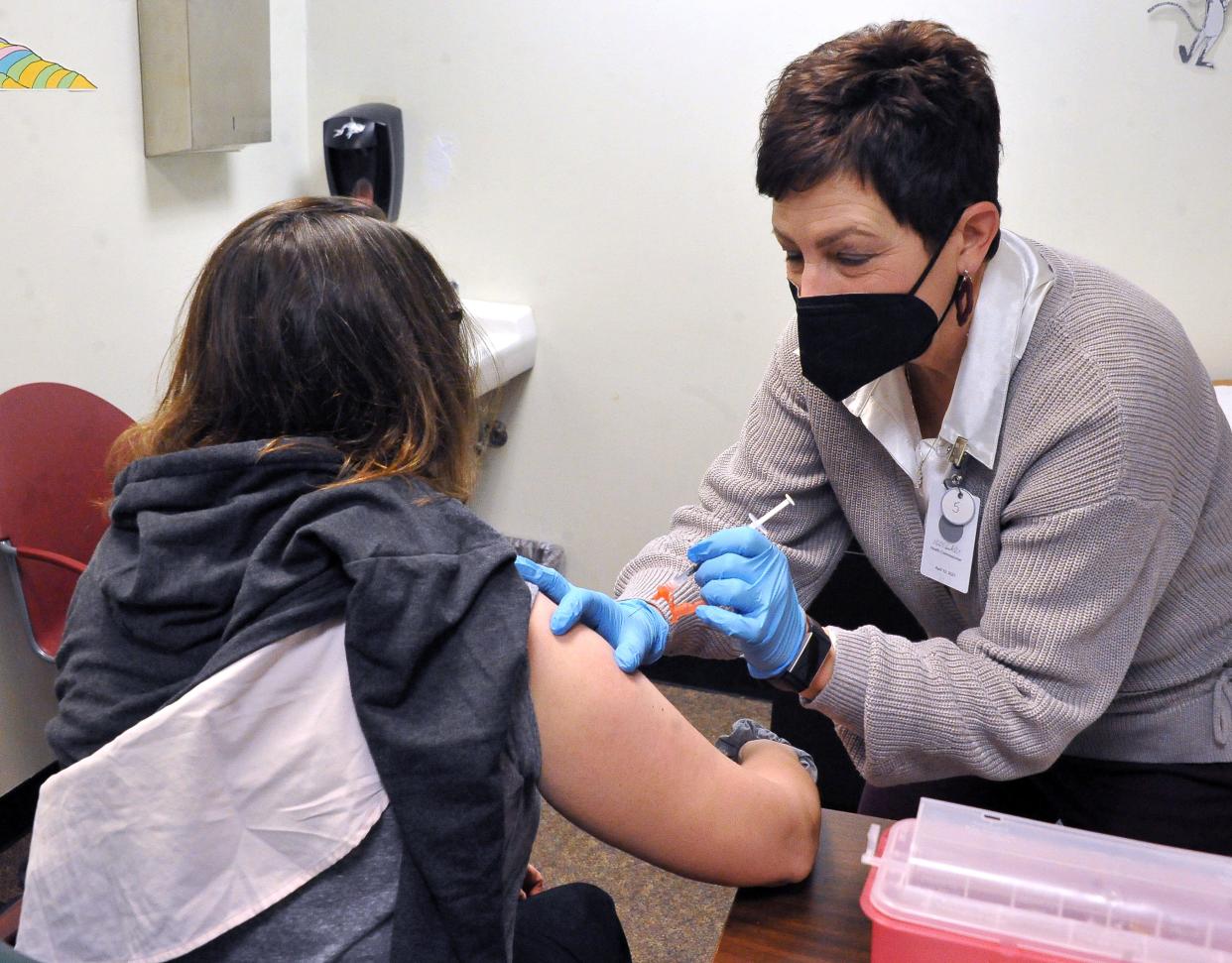 Michelle Woodall gets a COVID-19 vaccine shot Thursday from Kelly Smith at the Wayne County Health Department.