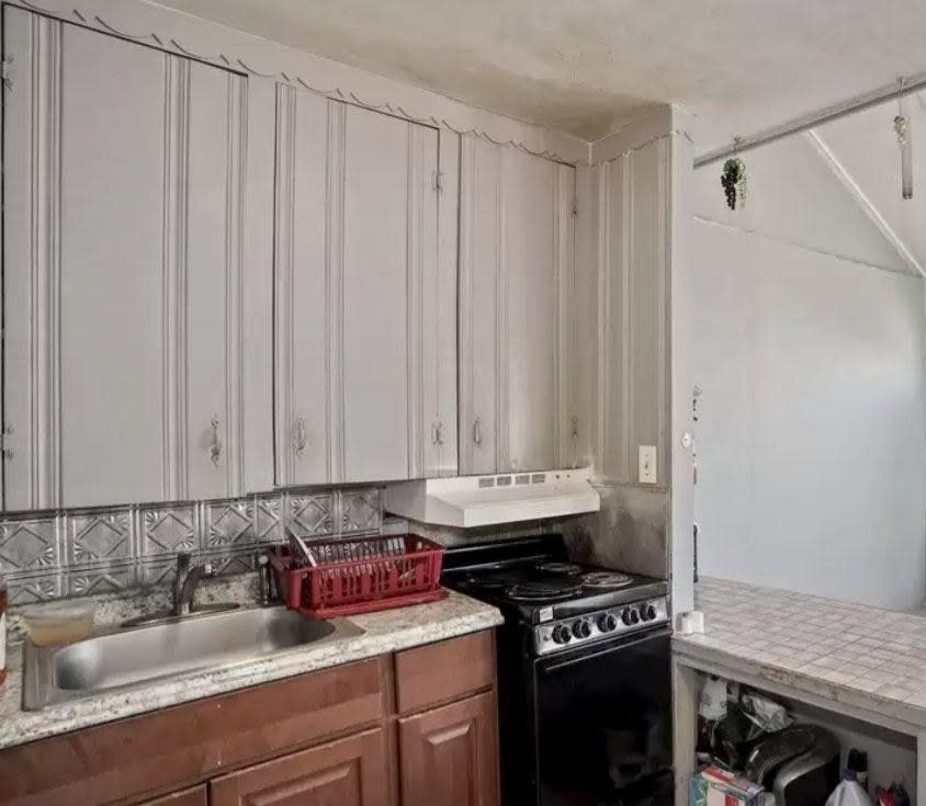 A very low stove hood below a cabinet