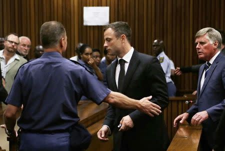 South African Olympic and Paralympic track star Oscar Pistorius is led to holding cells after he was sentenced at the North Gauteng High Court in Pretoria October 21, 2014. REUTERS/Themba Hadebe/Pool
