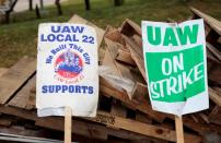 "UAW on strike" signs lean against a pile of wood on the picket line outside the General Motors Detroit-Hamtramck Assembly in Hamtramck