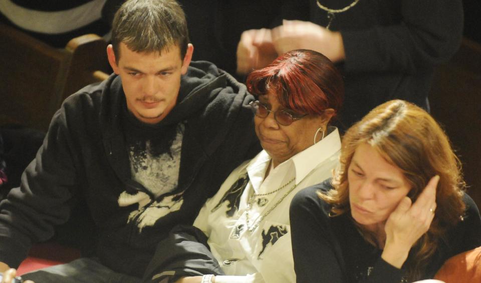 Deborah Hughes, center, sits with members of the family of Steve Utash of Clinton Township, who was beaten by a mob after he stopped to check on a child he hit in a traffic accident, during the Night of Healing service at Historic Little Rock Baptist Church in Detroit on Thursday, April 10, 2014. Hughes stepped in to stop the beating. Utash remains hospitalized in a medically induced coma. (AP Photo/Detroit News, Elizabeth Conley)