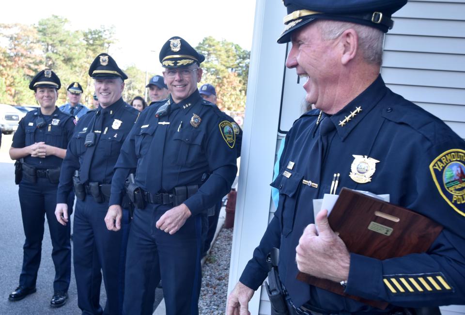 Retiring Yarmouth Police Chief Frank Frederickson, right, is greeted Friday by new chief Kevin Lennon, second from right, and other members of the department at a celebration Friday morning at the police station in West Yarmouth.