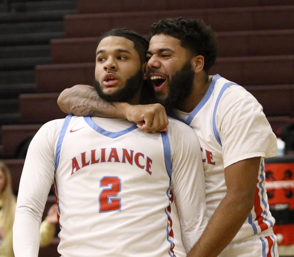 Kayden Davis, right, hugs teammate K'Vaughn Davis after the latter drilled a 3-pointer to tie and send the game into overtime in a district semifinal Thursday, March 2, 2023, at Boardman High School.