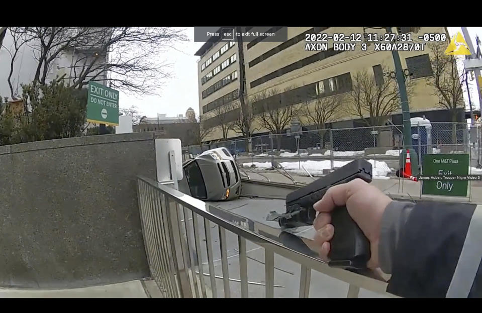 This photo taken from body cam video recorded Feb. 12, 2022, in Buffalo, N.Y., shows the hands of state trooper Anthony Nigro pointing his firearm as he approaches the overturned car of James Huber. On Monday, June 5, 2023, Nigro was charged with manslaughter for fatally shooting Huber after a high-speed car chase. (Office of the State Attorney General of New York via AP)