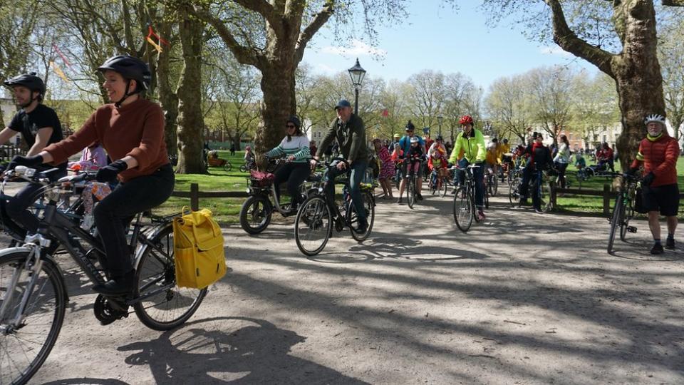 Riders cycle through Queen Square in the centre of Bristol