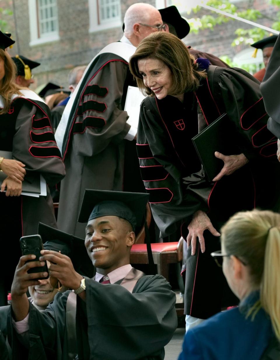 House Speaker Nancy Pelosi stops to be in a photo with a Brown University graduate after delivering a commencement speech on Sunday.