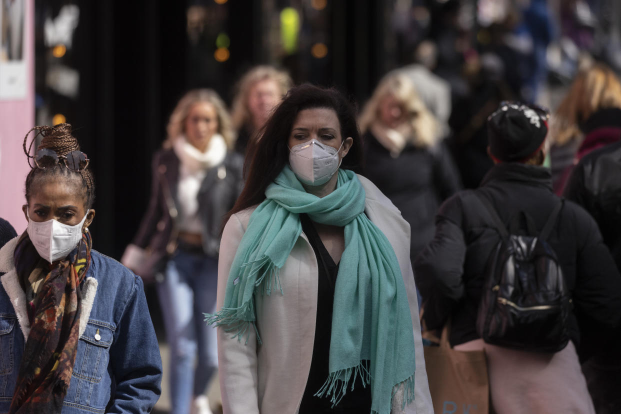 LONDON, ENGLAND - APRIL 01: A woman wears a face mask while walking on Oxford Street on April 01, 2022 in London, England. From today, guidance on voluntary COVID-status certification in domestic settings and the use of the NHS Covid Pass plus requirements for employers to consider COVID-19 in health and safety risk assessments is removed. Free universal symptomatic and asymptomatic testing for the general public is no longer provided with Lateral Flow Tests now available to purchase on the High Street. (Photo by Dan Kitwood/Getty Images)