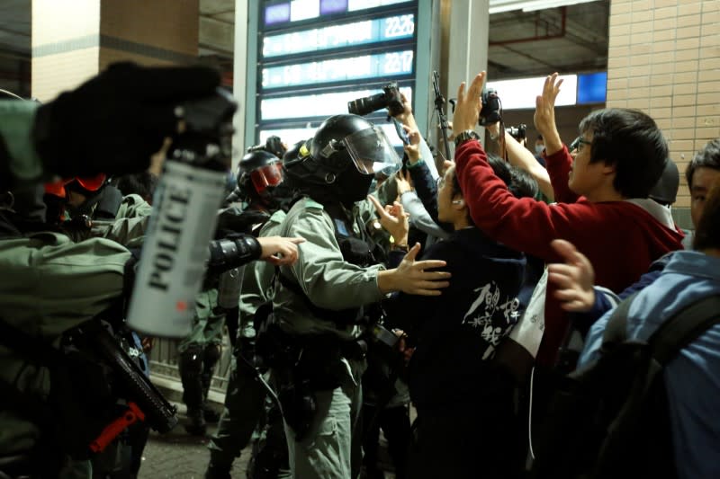 Police officers brandish pepper spray to disperse protesters who gathered at the site of an attack six months ago by an armed mob on anti-government demonstrators at the district of Yuen Long in Hong Kong