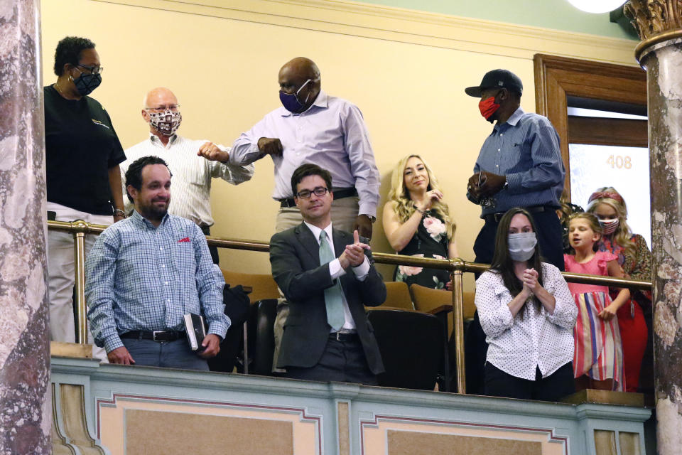 Observers in the gallery applaud after the Senate voted to change the Mississippi flag Sunday, June 28, 2020, at the Capitol in Jackson, Miss. Mississippi lawmakers voted to surrender the Confederate battle emblem from the flag, triggering raucous applause and cheers more than a century after white supremacist legislators adopted the design a generation after the South lost the Civil War. Republican Gov. Tate Reeves has said he will sign the bill, and the state flag would lose its official status as soon as he signs the measure. (AP Photo/Rogelio V. Solis)