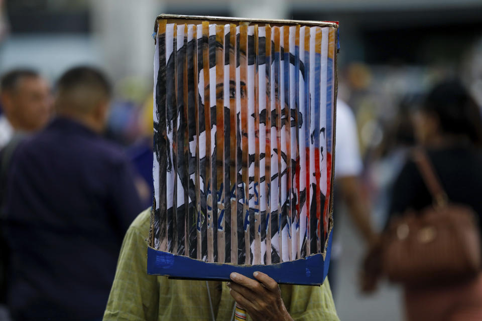Un hombre con un cartel que recrea la cara de la líder opositora María Corina Machado y del candidato presidencial Edmundo González en el acto de cierre de campaña en Caracas, Venezuela, el jueves 25 de julio de 2024. (AP Foto/Cristian Hernández)