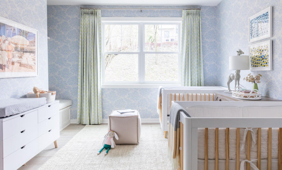 Nursery room with two cots and blue wallpaper