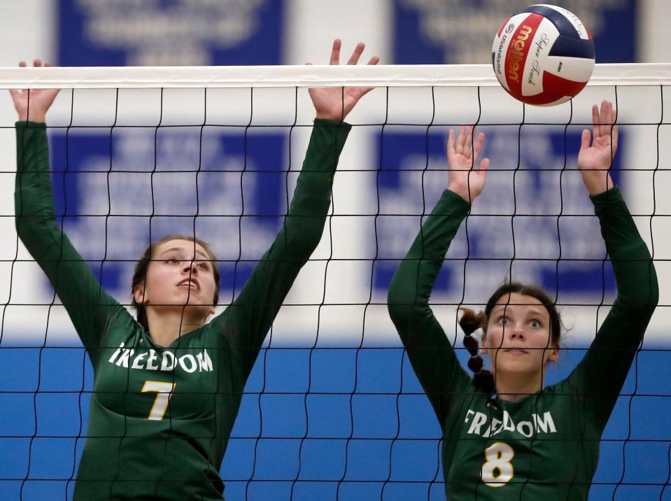 Freedom's Breana Griesbach (7) and Laken Greiner (8) defend at the net against Wrightstown during a North Eastern Conference volleyball match Sept. 19.