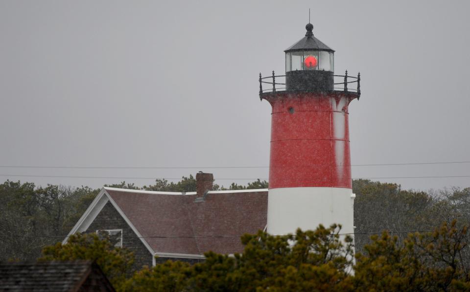 A light snow clings to the side of Nauset Light Tuesday morning.