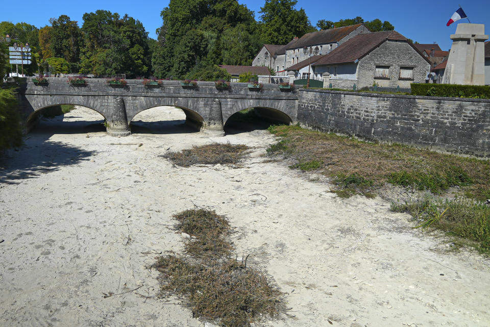 A view the dried-up river Tille in Lux, France, Tuesday Aug. 9, 2022. Burgundy, home to the source of the Seine River which runs through Paris, normally is a very green region. This year, grass turned yellow, depriving livestock from fresh food, and tractors send giant clouds of dust in the air as farmers work in their dry fields. (AP Photo/Nicholas Garriga)