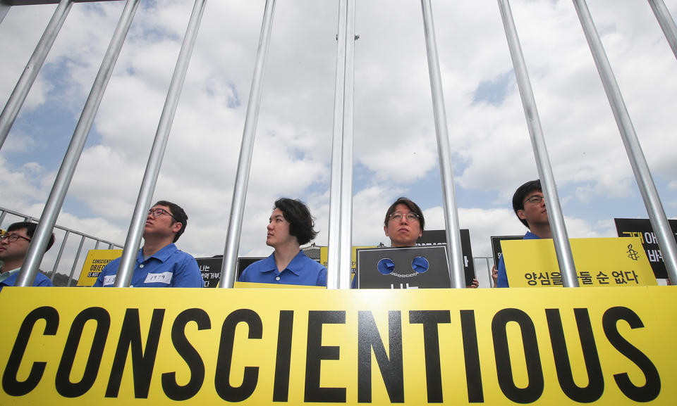 <p>Protesters hold placards behind mock prison bars in Seoul, South Korea, May 15, 2017, as they rally to demand the government not to punish conscientious objectors and introduce alternative service options for them in observance of the International Conscientious Objectors Day that fell on the same day. The rally was organized by Amnesty International Korea. (Photo: Yonhap South/EPA) </p>