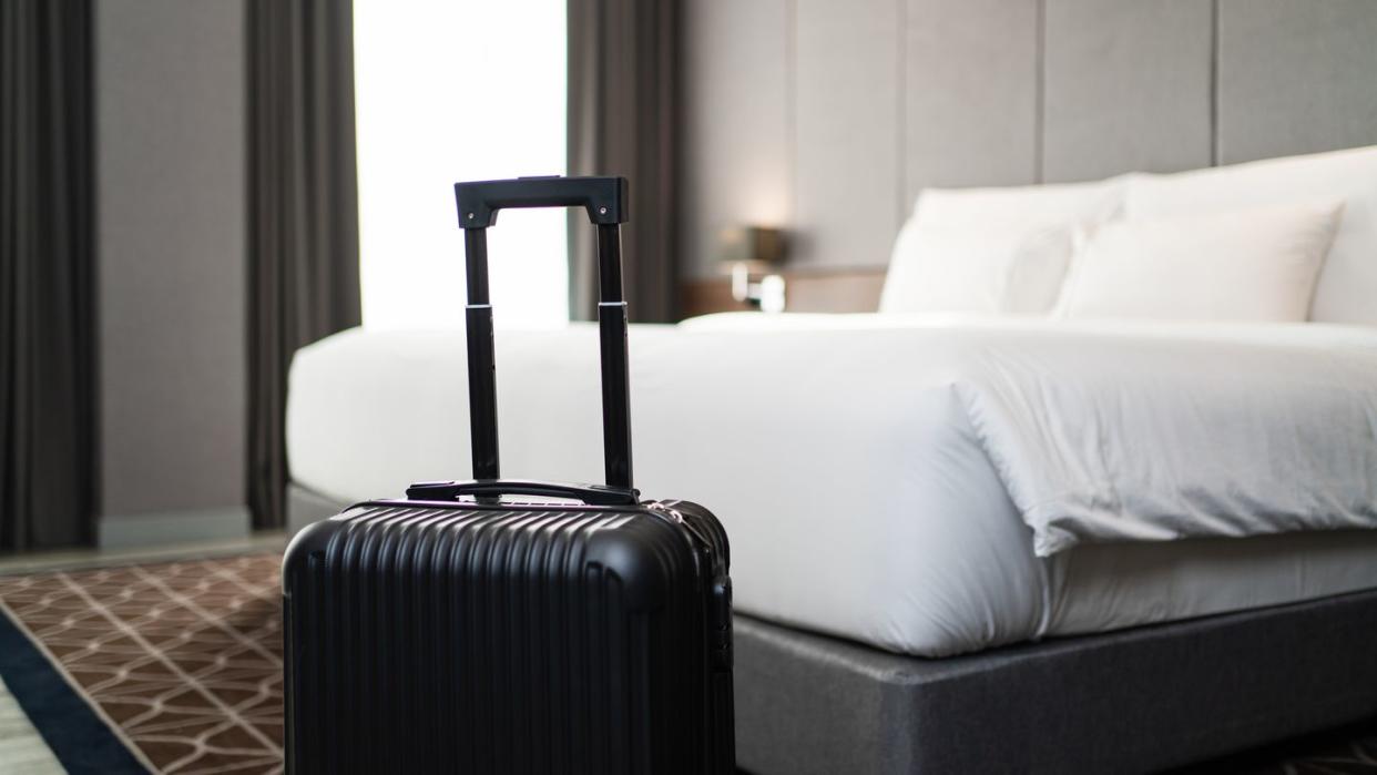 a suitcase placing in front of the bedroom in luxury hotel room