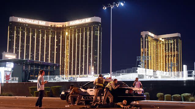 Las Vegas police take cover near the Mandalay Bay Hotel where a gunman was firing at people below. Source: Getty